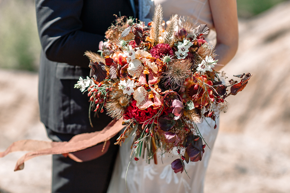 Bukiet ślubny z czerwonych kwiatów i traw