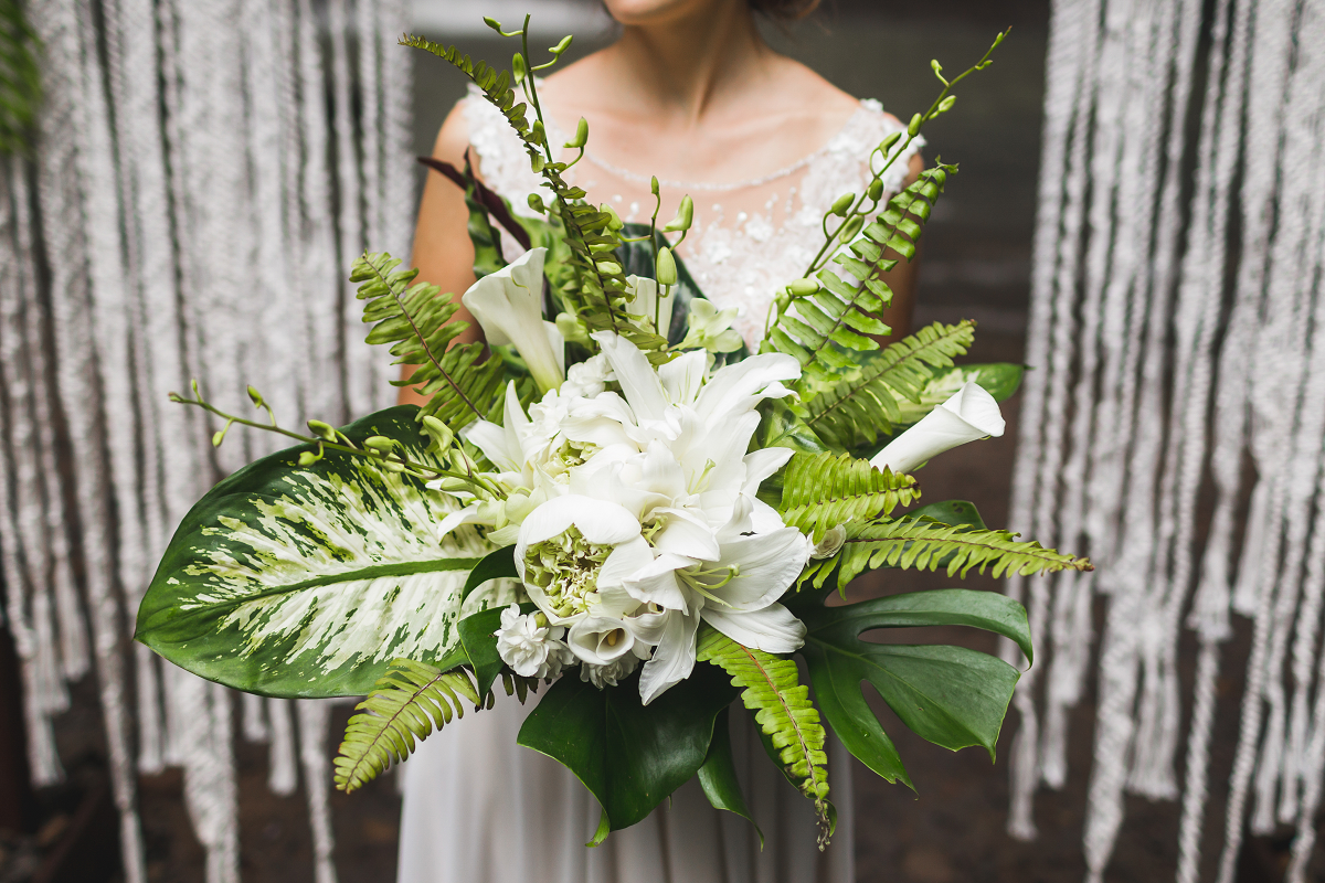 Bukiet ślubny z białych kwiatów i tropikalnych liści