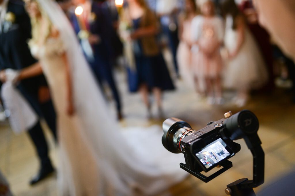 jak wybrać kamerzystę na wesele - kamera nagrywająca gości weselnych i parę młodą na sali
