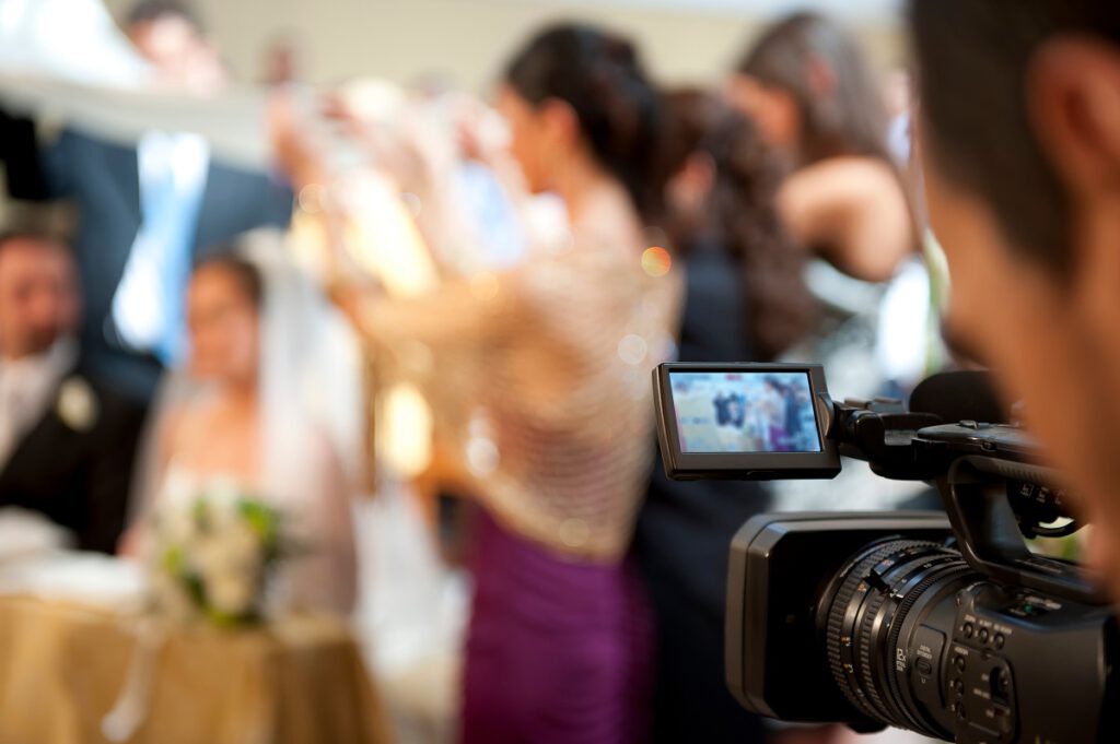 jak wybrać kamerzystę na wesele - kamerzysta nagrywający gości na sali
