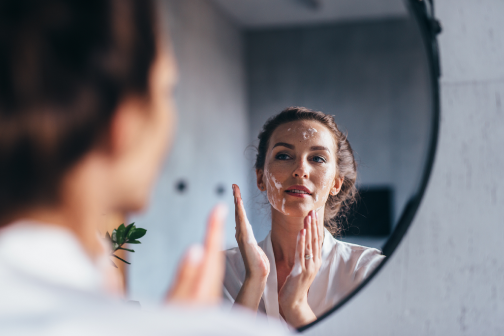Jak przygotować cerę na makijaż ślubny - kobieta oczyszczająca twarz pianką