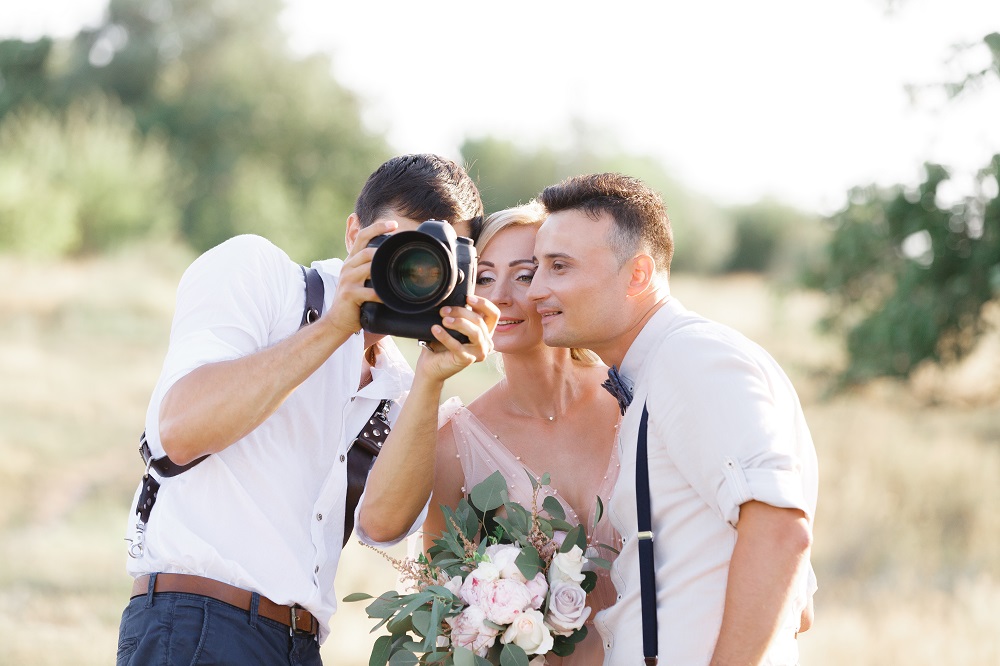 Jak wybrać fotografa ślubnego - fotograf pokazuje zdjęcia parze młodej