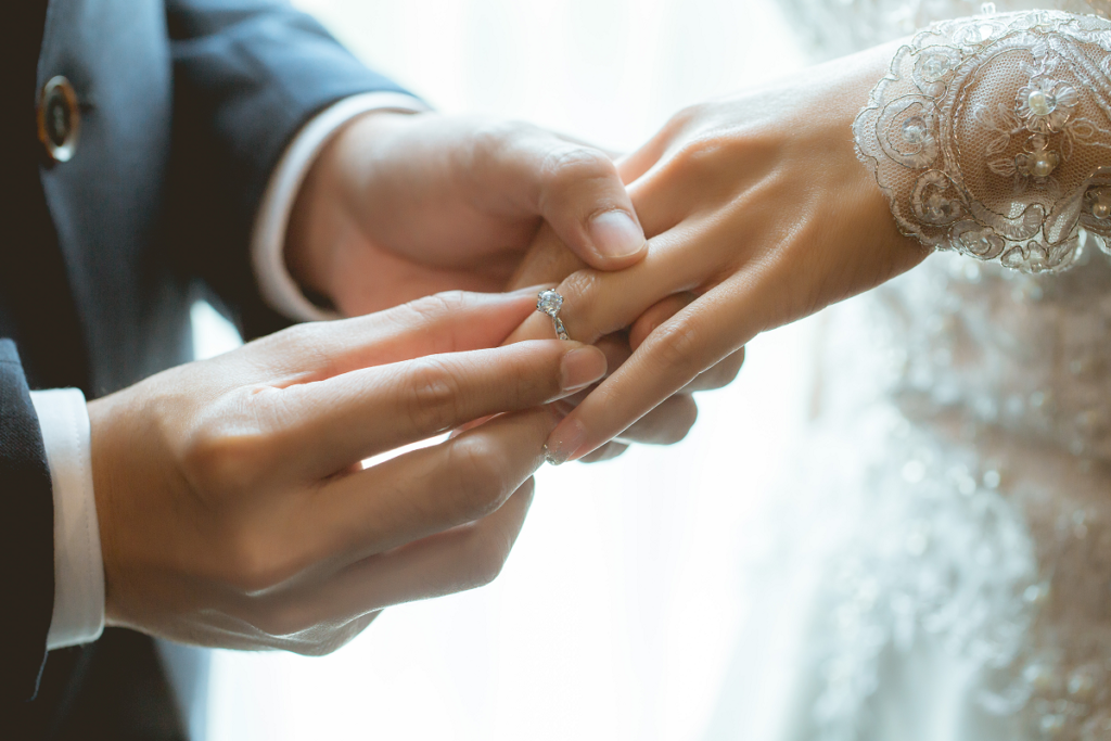Protokół przedślubny - obrączki ślubne na dłoniach nowożeńców