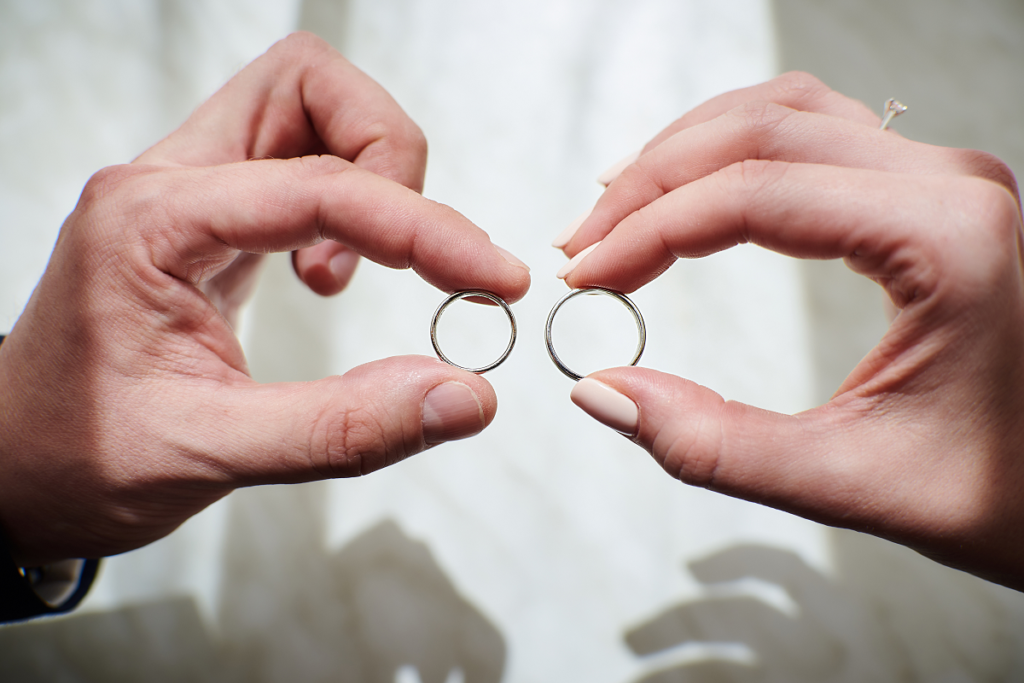 Protokół przedślubny - obrączki trzymany w ręku przez nowożeńców