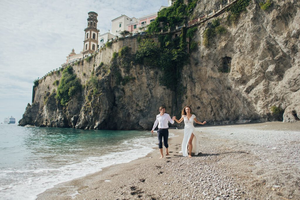 ślub za granicą - para młoda przechadzająca się po włoskiej plaży