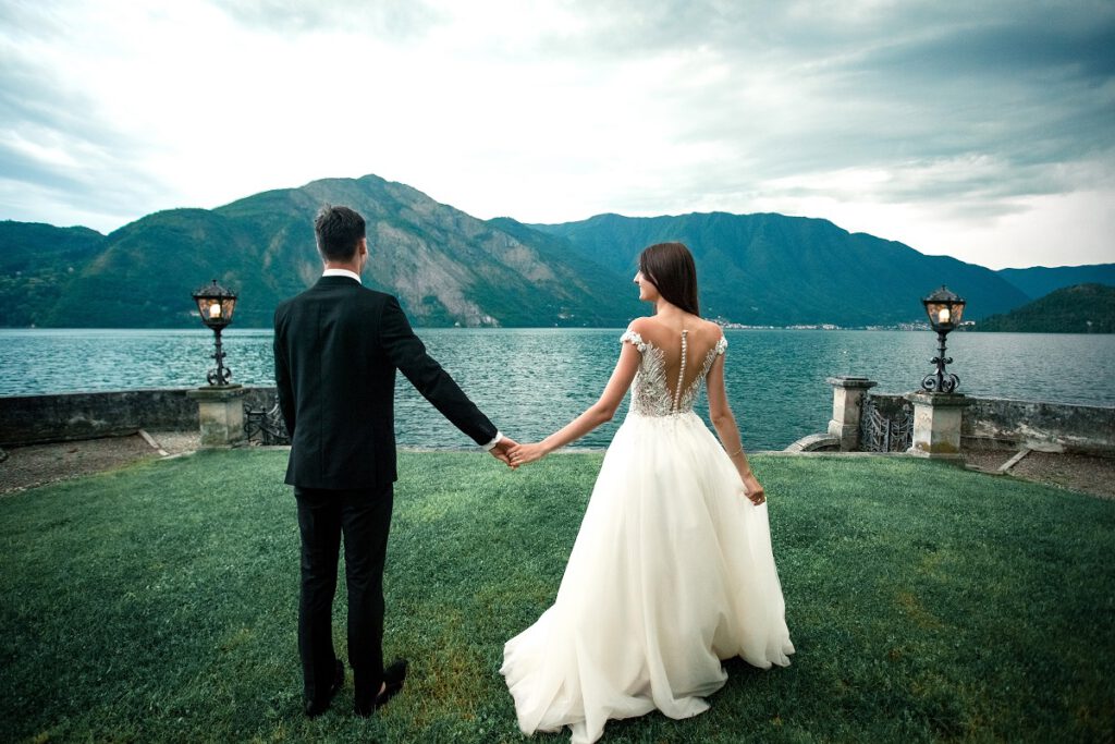 góralskie wesele - para młoda trzymająca się za ręce na tle górskiego jeziora