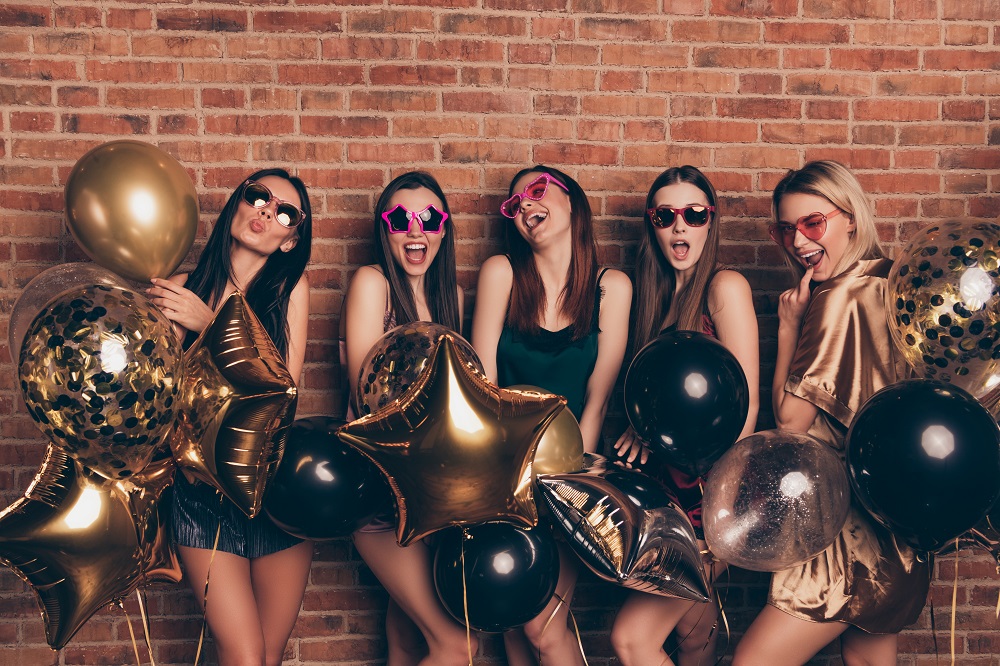 zabawy na wieczór panieński - roześmiane dziewczyny z czarnymi i złotymi balonami