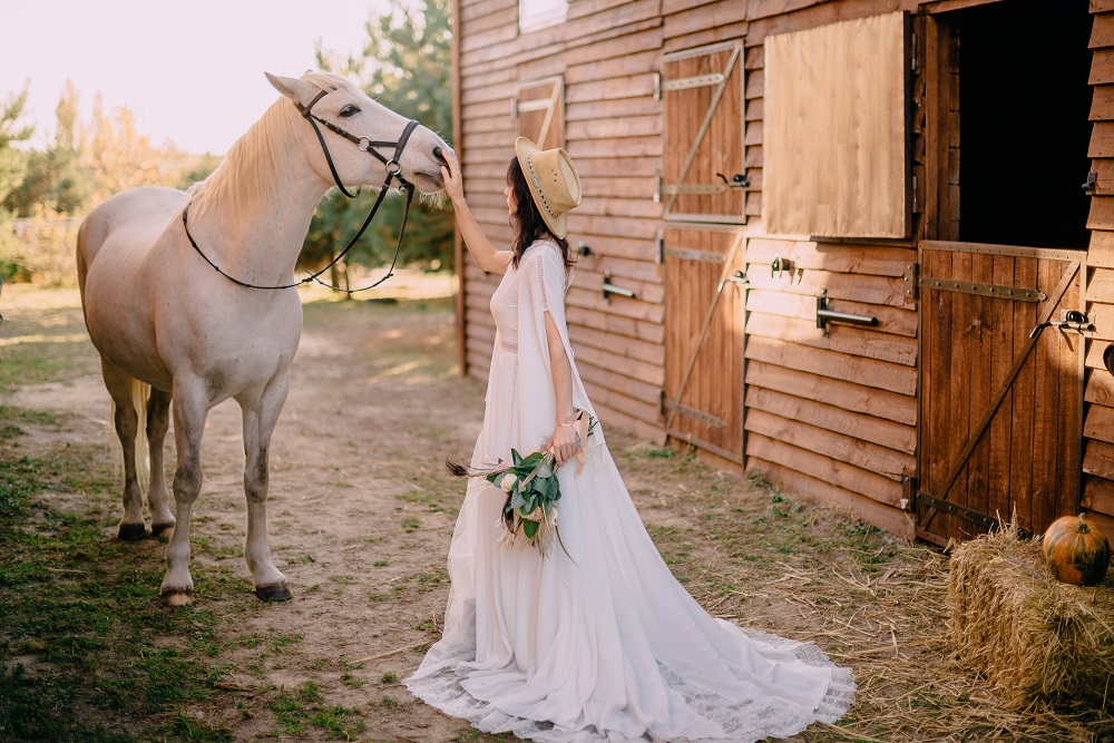 Wesele w stodole - panna młoda z koniem przed stodołą