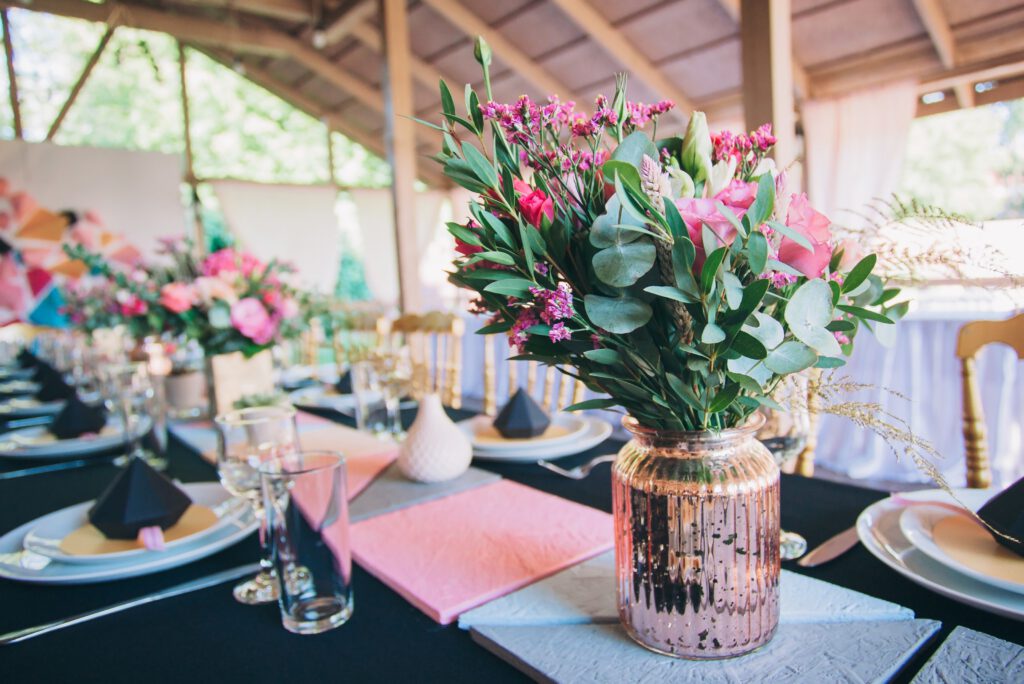 Wesele w stodole - bukiet kwiatów na weselnym stole w stodole