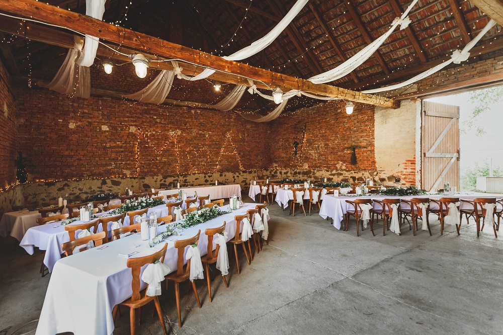 Wesele w stodole - stoły weselne z białymi obrusami
