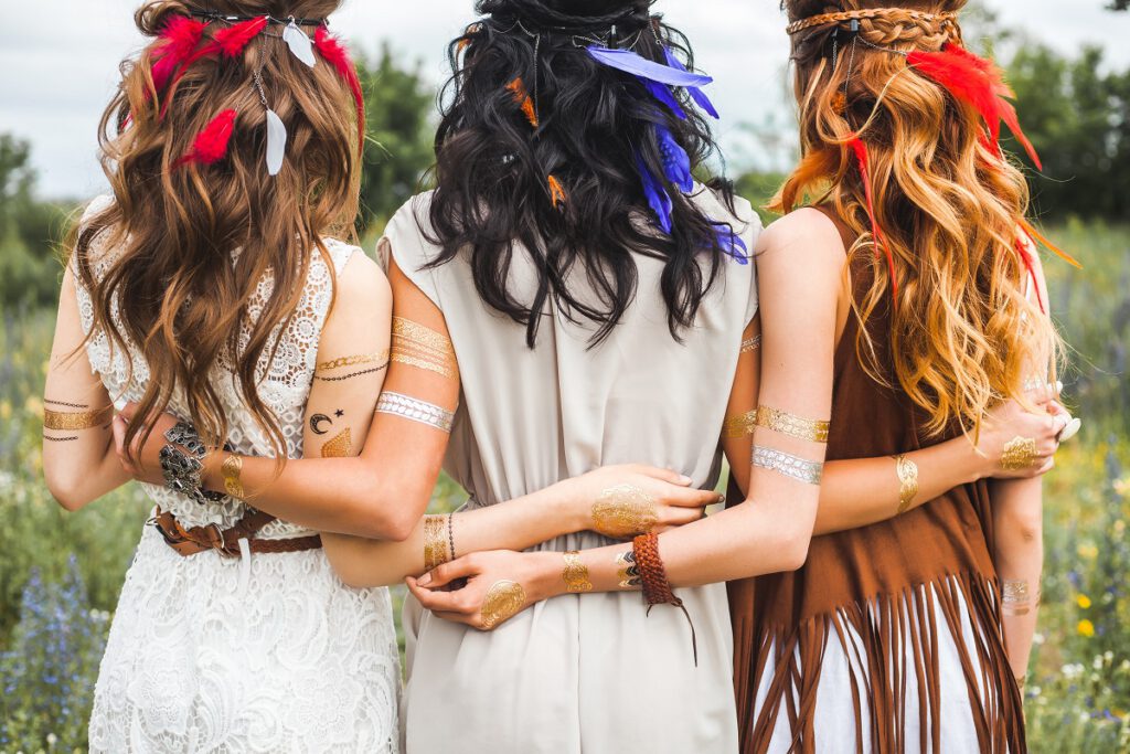 fryzury boho - trzy kobiety w stylu boho z piórkami we włosach