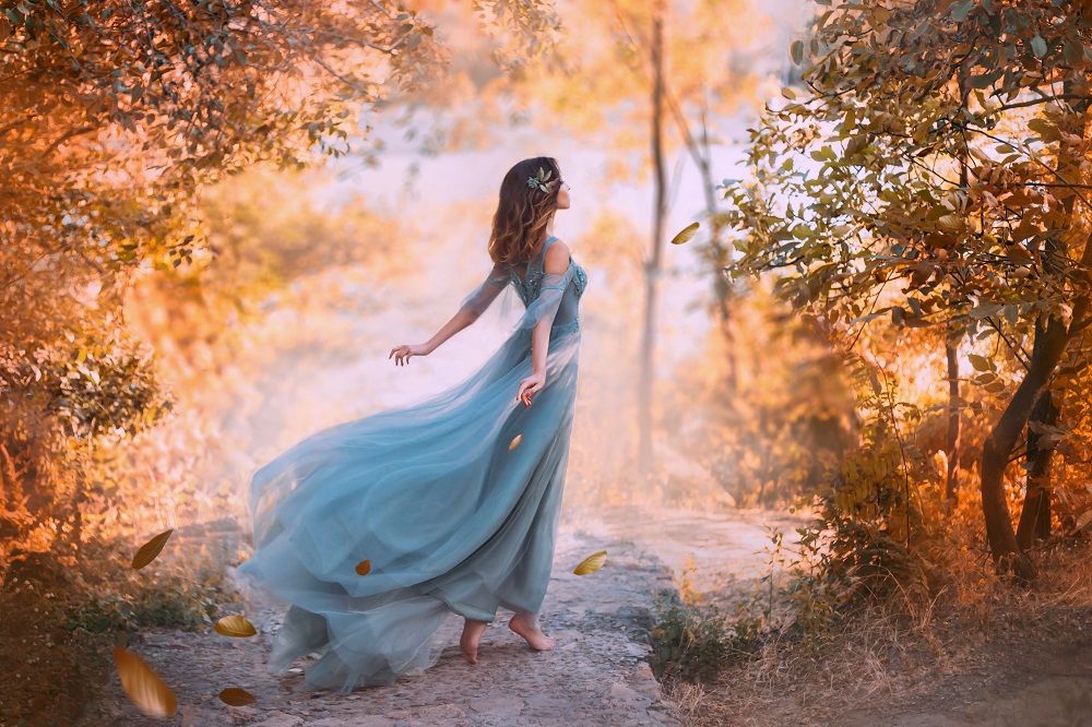 Kolorowe suknie ślubne. Śliczna dziewczyna w niebieskiej sukience w lesie..