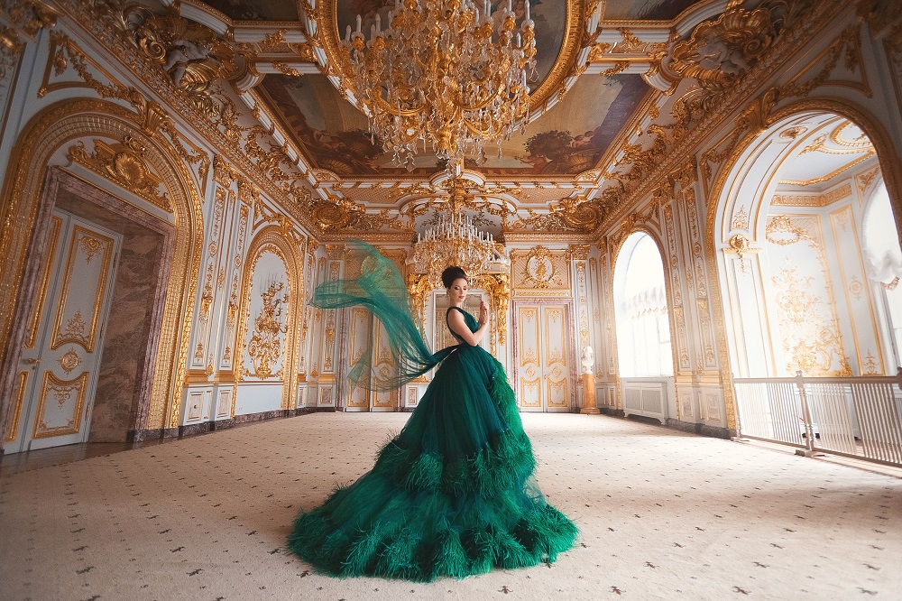 Kolorowe suknie ślubne. Kobieta w majestatycznej zielonej sukni w pałacu.