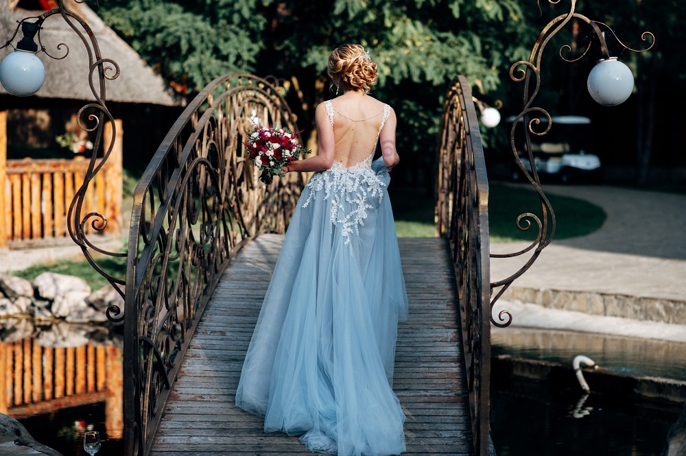 Kolorowe suknie ślubne. Panna młoda w niebieskiej sukni ślubnej na moście.