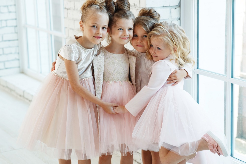Kącik dla dzieci na weselu. Cztery małe dziewczynki w różowych sukienkach.