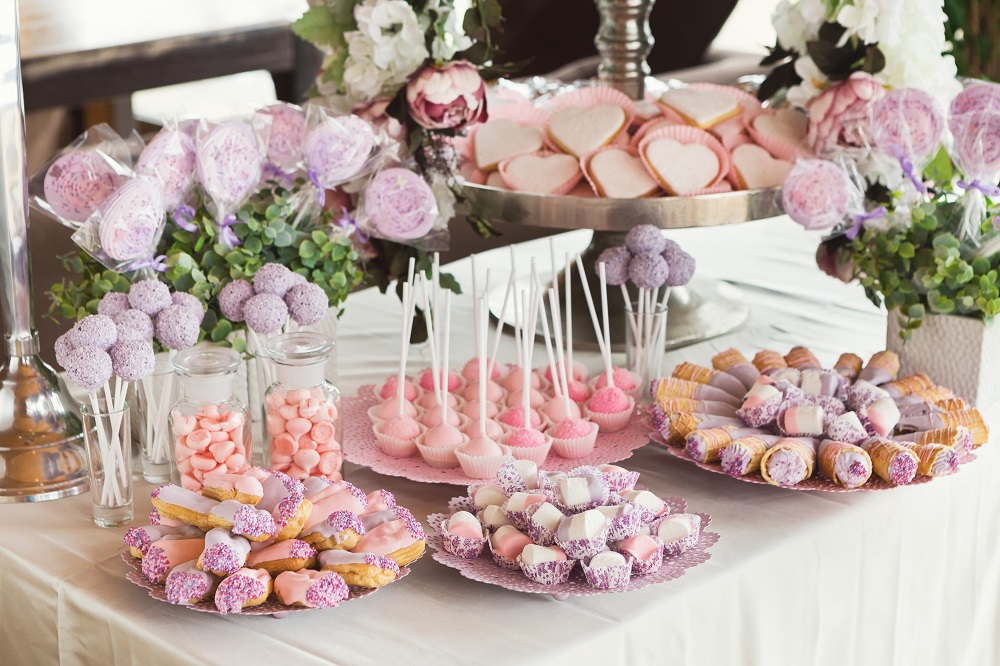 Kącik dla dzieci na weselu. Słodki stół z różowymi przysmakami.