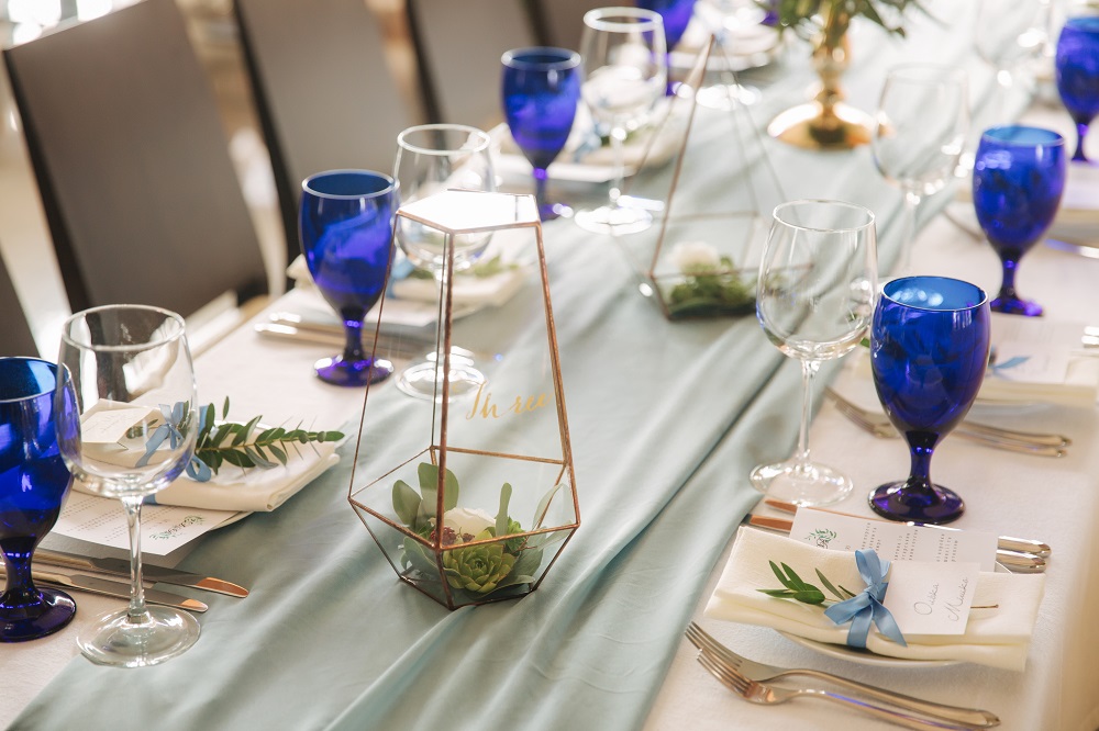 style weselne - stół weselny z pięknymi kratowymi kielichami i roślinami w szkle
