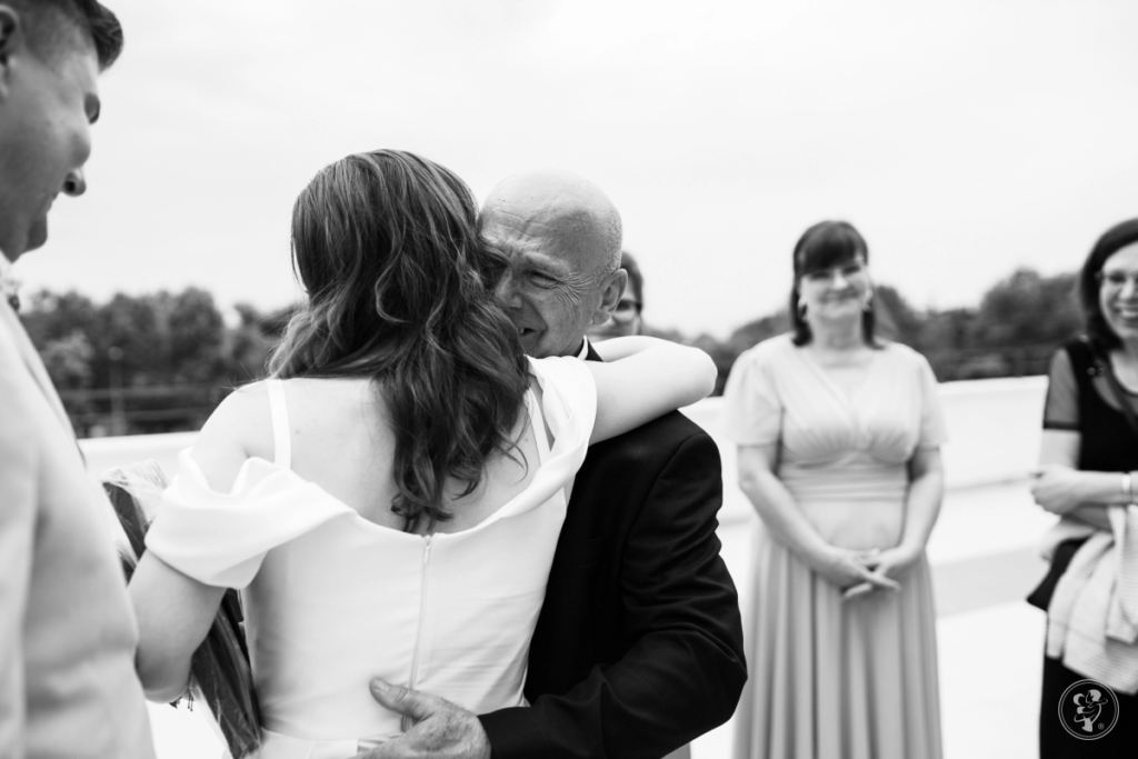 Reportaż ślubny - mężczyzna przytula pannę młodą