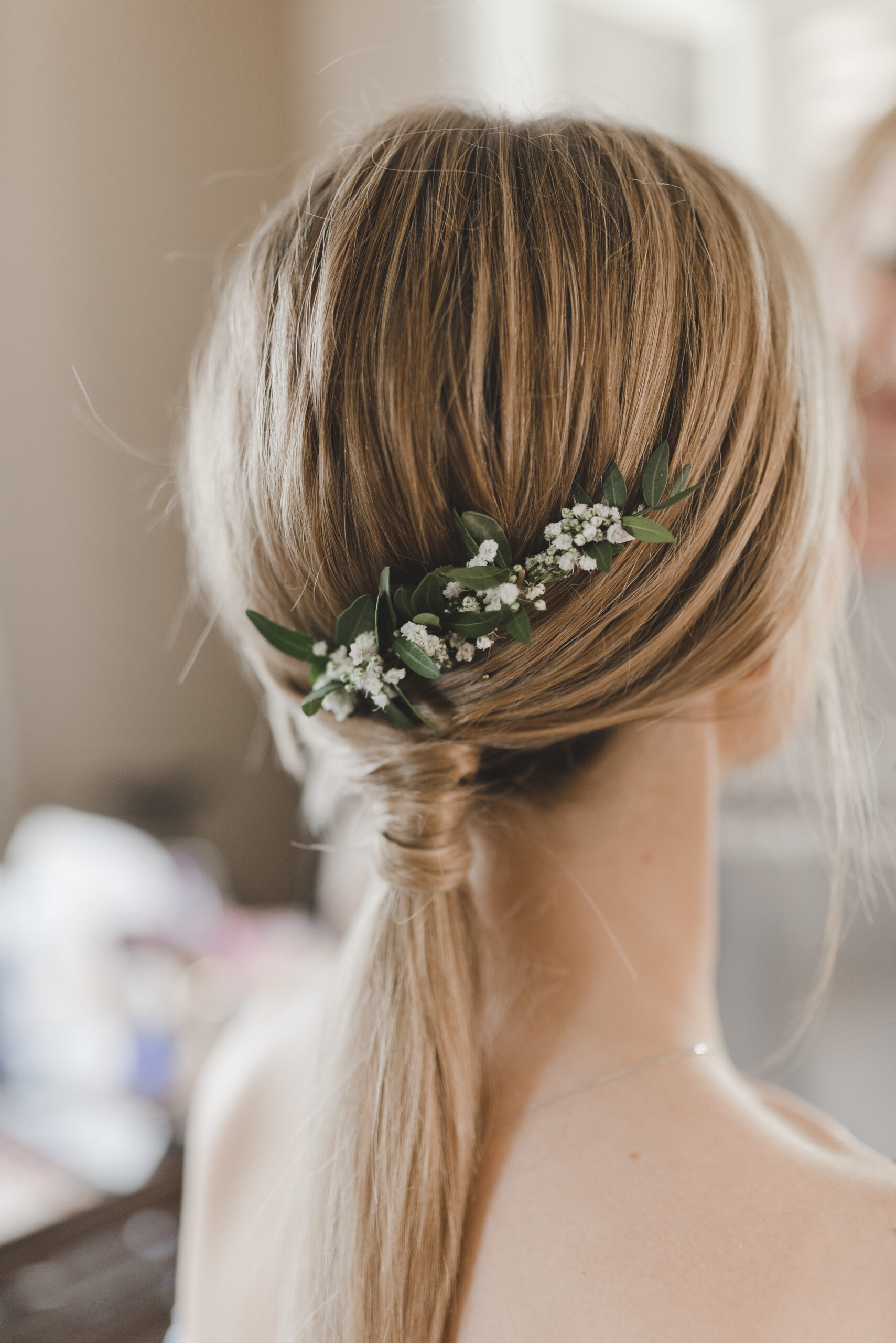 Przykład fryzury na wesele. Subtelny kucyk na wesele z drobnymi kwiatami