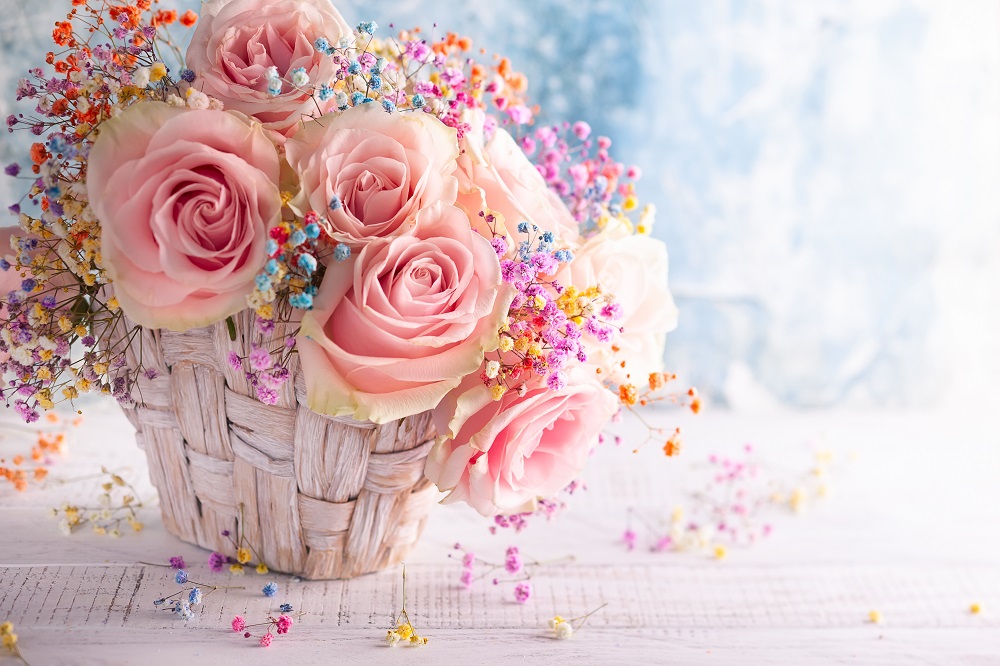 Bukiety ślubne z róż. Piękne różowe róże w ozdobnym koszyku oraz kolorowa gipsówka.
