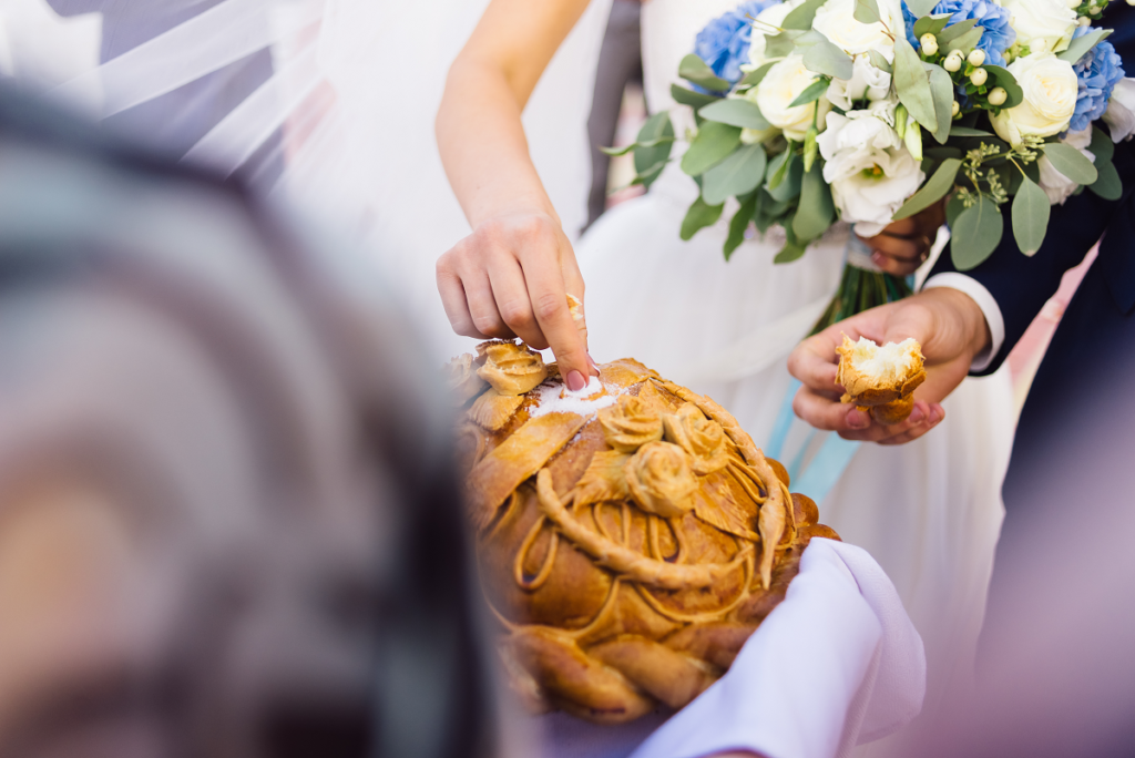 Powitanie młodej pary chlebem i solą - krojenie chleba przez parę młodą