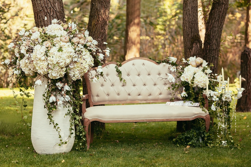 Ślub humanistyczny. Piękna sofa i kwiaty w ogrodzie.