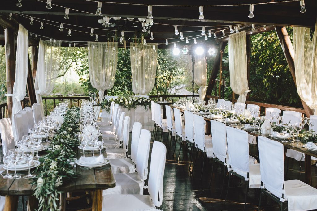 przyjęcie weselne - stoły i krzesła rozstawione w altanie podczas przyjęcia weselnego