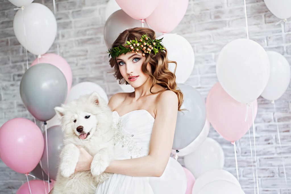 dekoracje z balonów - panna młoda z białym psem na tle balonów