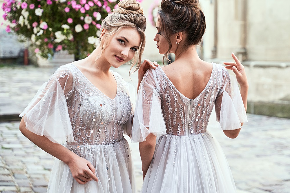suknia ślubna z długim rękawem - dwie panny młode w eleganckich sukniach