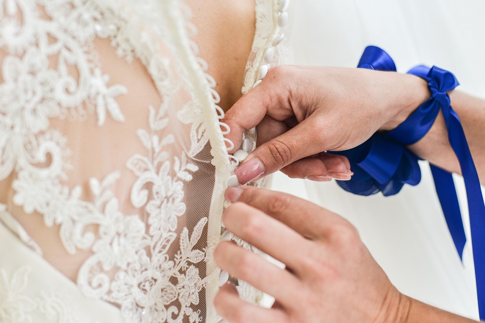 Materiał na suknię ślubną - druhna zapinająca suknię ślubną pannie młodej