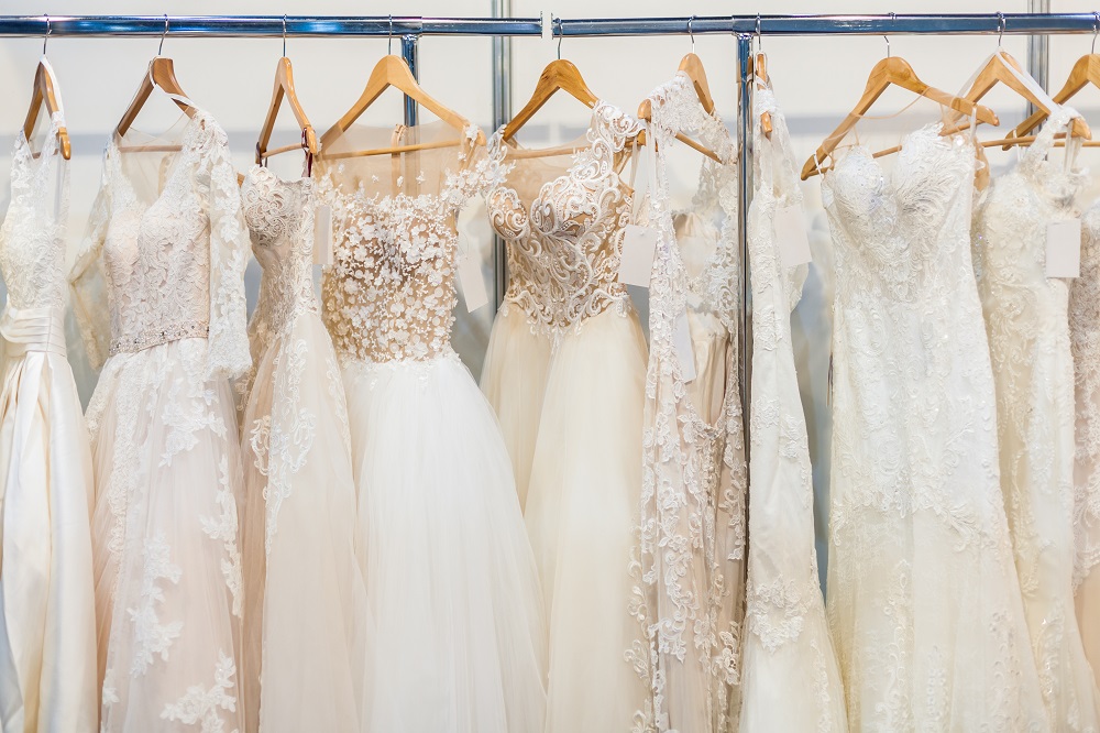 Materiał na suknię ślubną - piękne, białe suknie wiszące w salonie