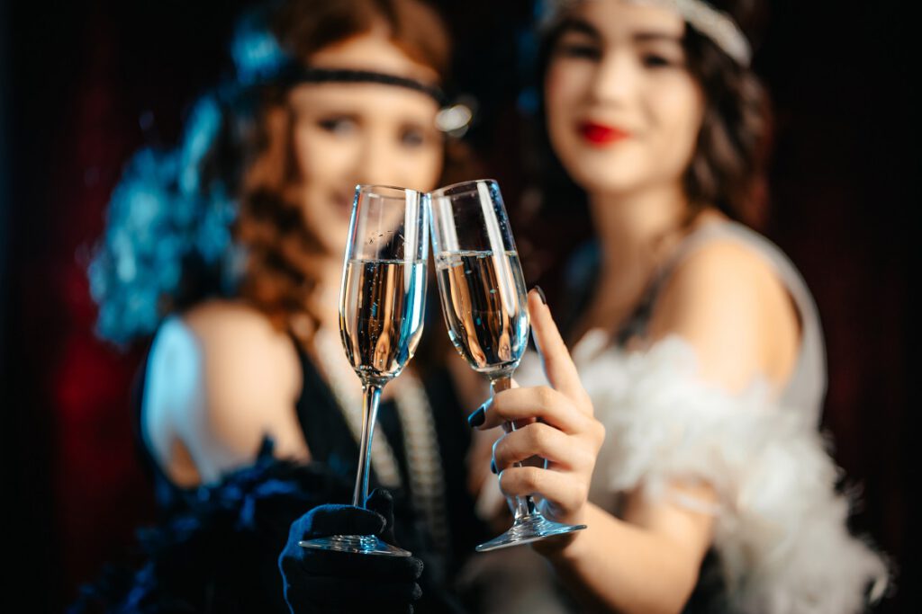 Lata 20 moda - dwie dziewczyny z kieliszkiem szampana
