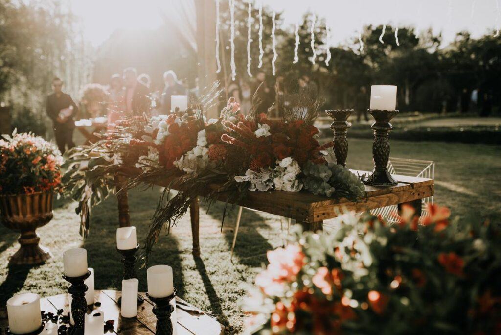 Stół z kwiatami i świecami przygotowany na wesele w ogrodzie