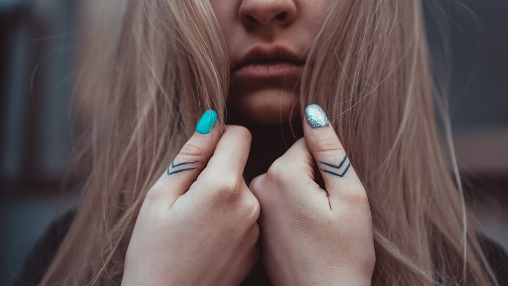 Tatuaż obrączka - dziewczyna z tatuażami na kciukach