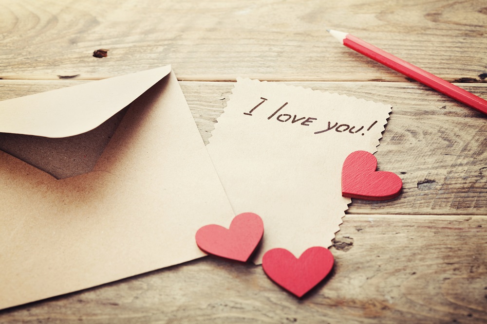 List miłosny obok minimalistycznej kopert i serduszek