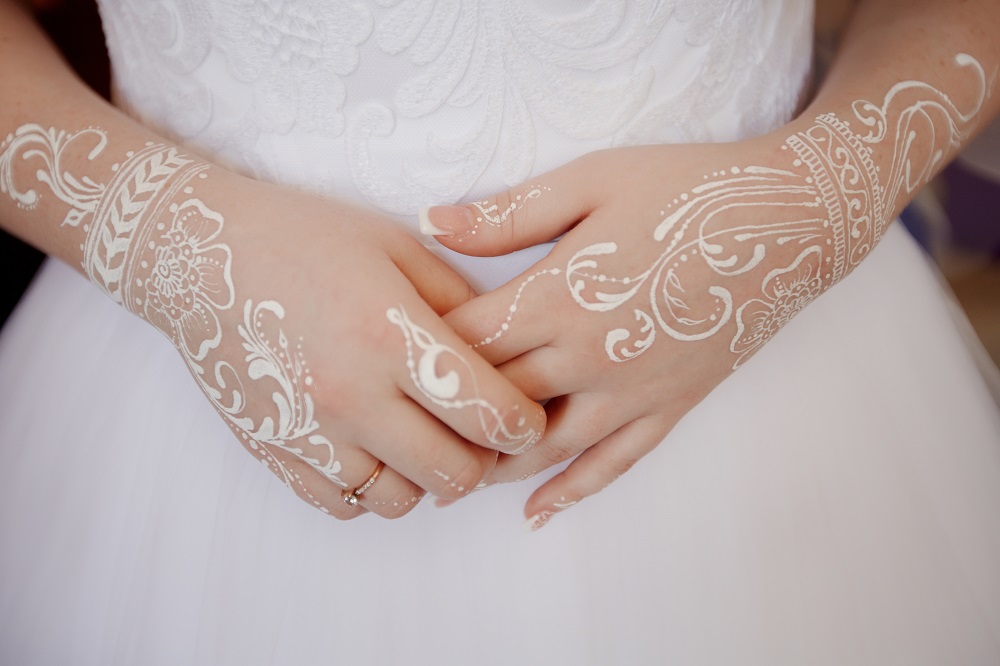 Tatuaż obrączka - panna młoda z tatuażami wykonanymi białym atramentem na rękach.