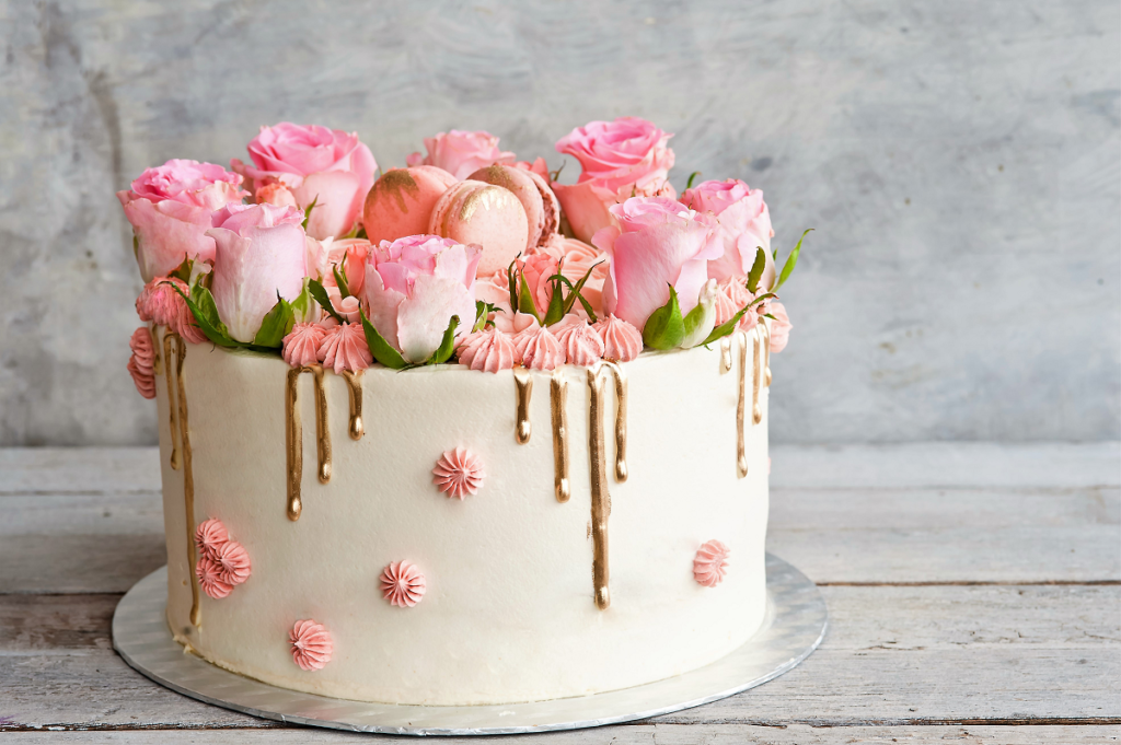Tort na wieczór panieński z różowymi kwiatami i makaronikami