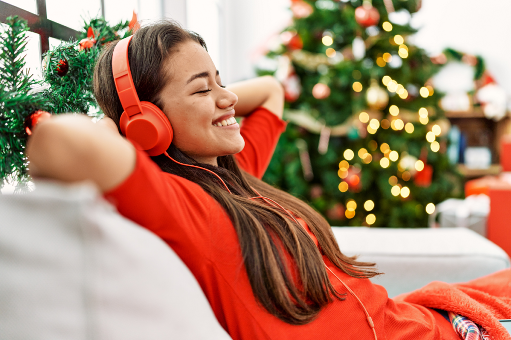 Świąteczne piosenki - kobieta w czerwonych słuchawkach