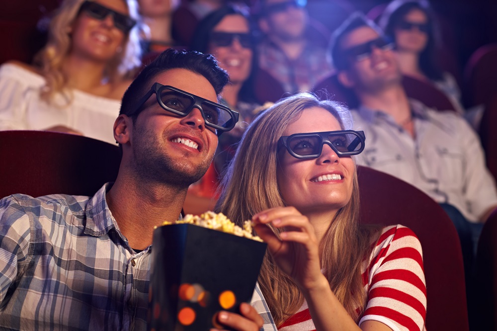 Prezent dla dwojga - para siedząca w kinie i jedząca popcorn