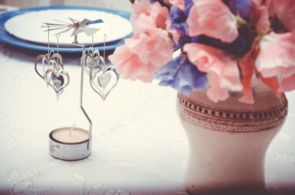 udekorowana świeczka i kwiaty na stole weselnym