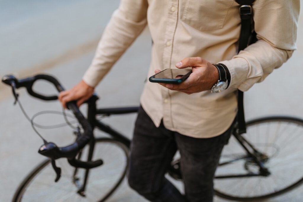 mężczyzna z rowerem pisze wiadomość na telefonie