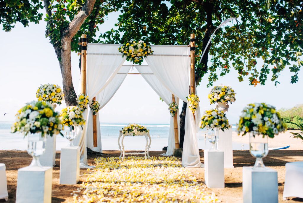 Dekoracja na ślub na plaży z żółtych i białych kwiatów