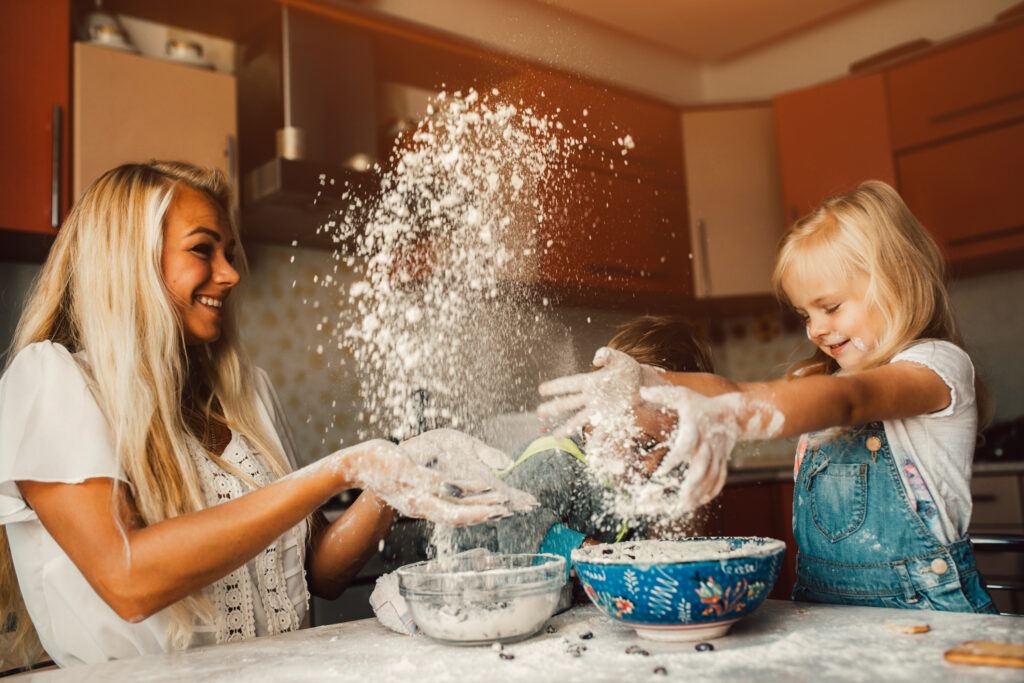 mama z dziećmi robiąca domową ciastolinę 
