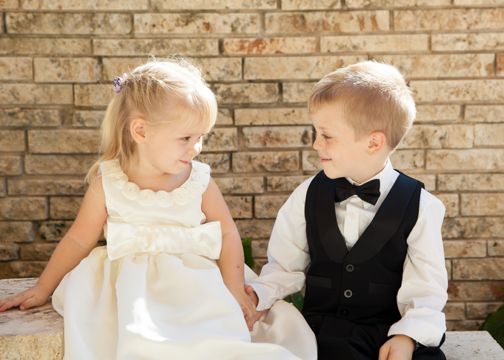 Dzieci na ślubie - mała dziewczynka i chłopiec w odświętnych strojach 