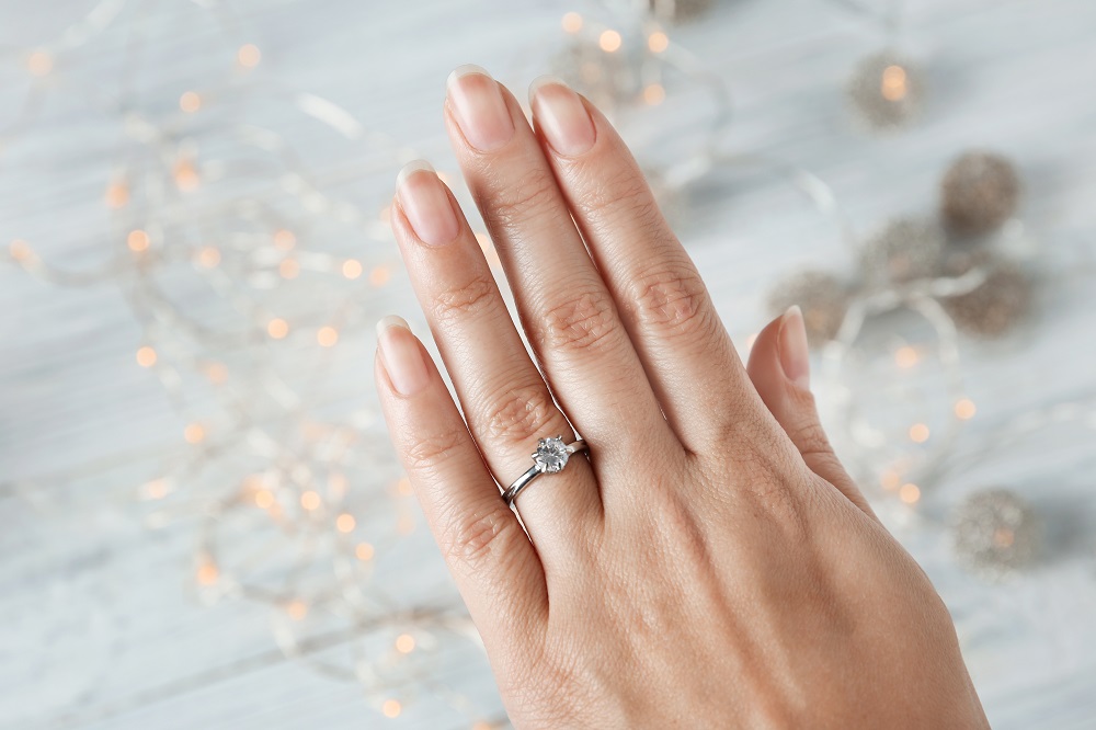 na którym palcu nosi się pierścionek zaręczynowy - dłoń kobiety z pierścionkiem zaręczynowym