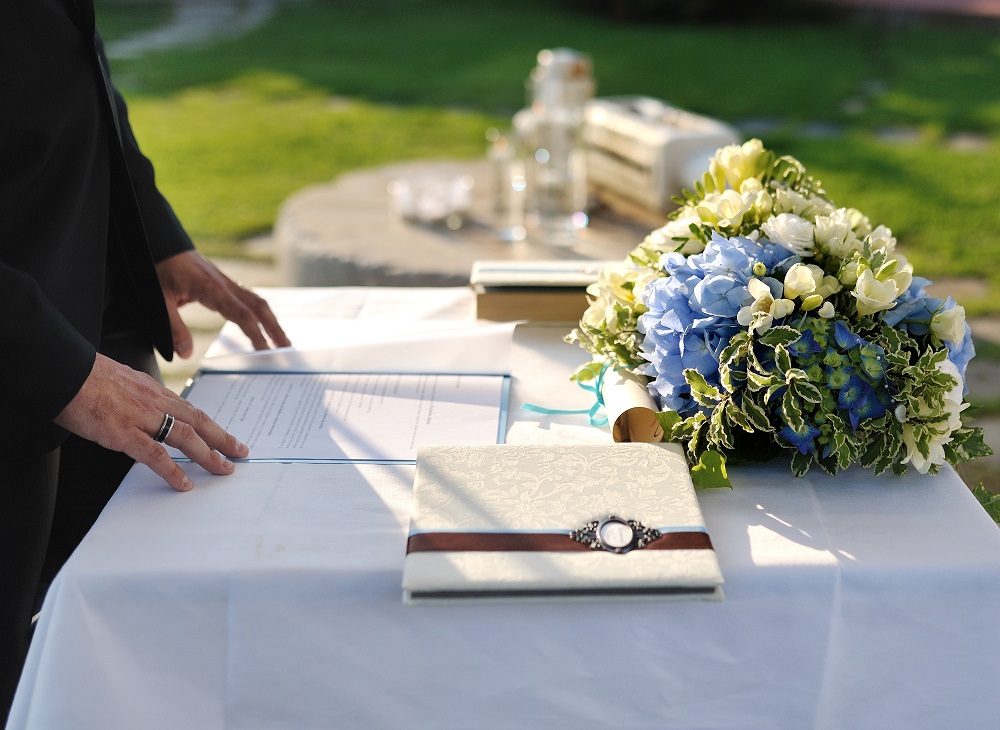 Ślub cywilny. Pan młody czyta dokumenty podczas ślubu cywilnego.