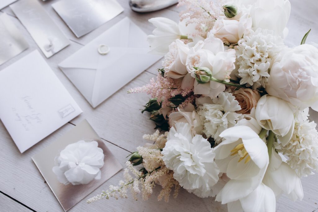 Odmiana nazwisk na zaproszeniach ślubnych - białe koperty z kwiatami