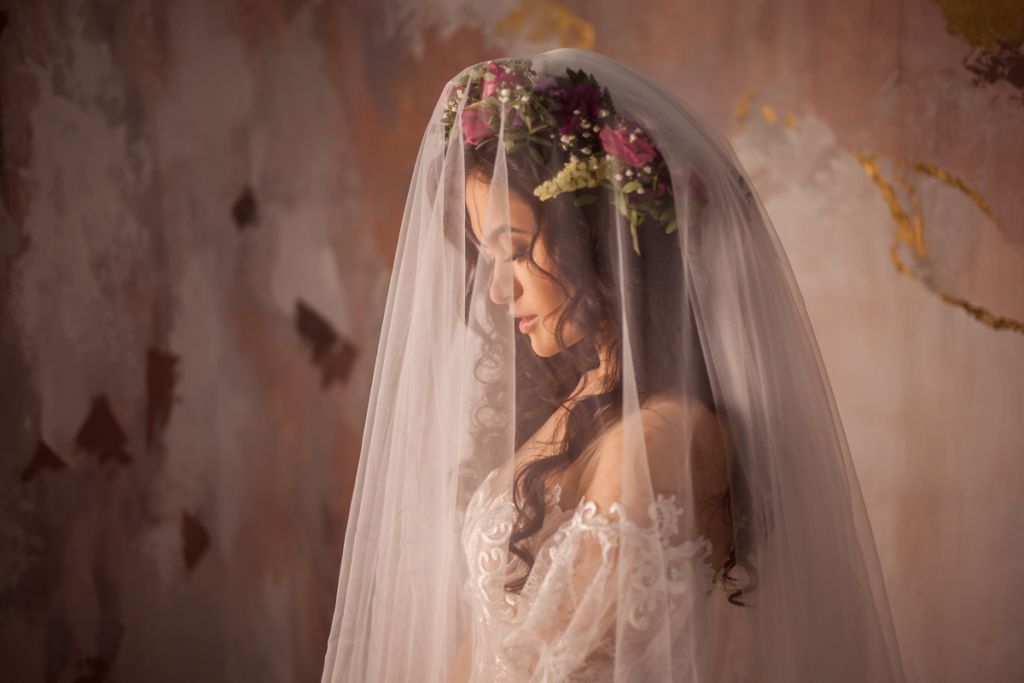 Wianek ślubny -  panna młoda w pięknej sukni ślubnej z welonem i wiankiem na głowie 