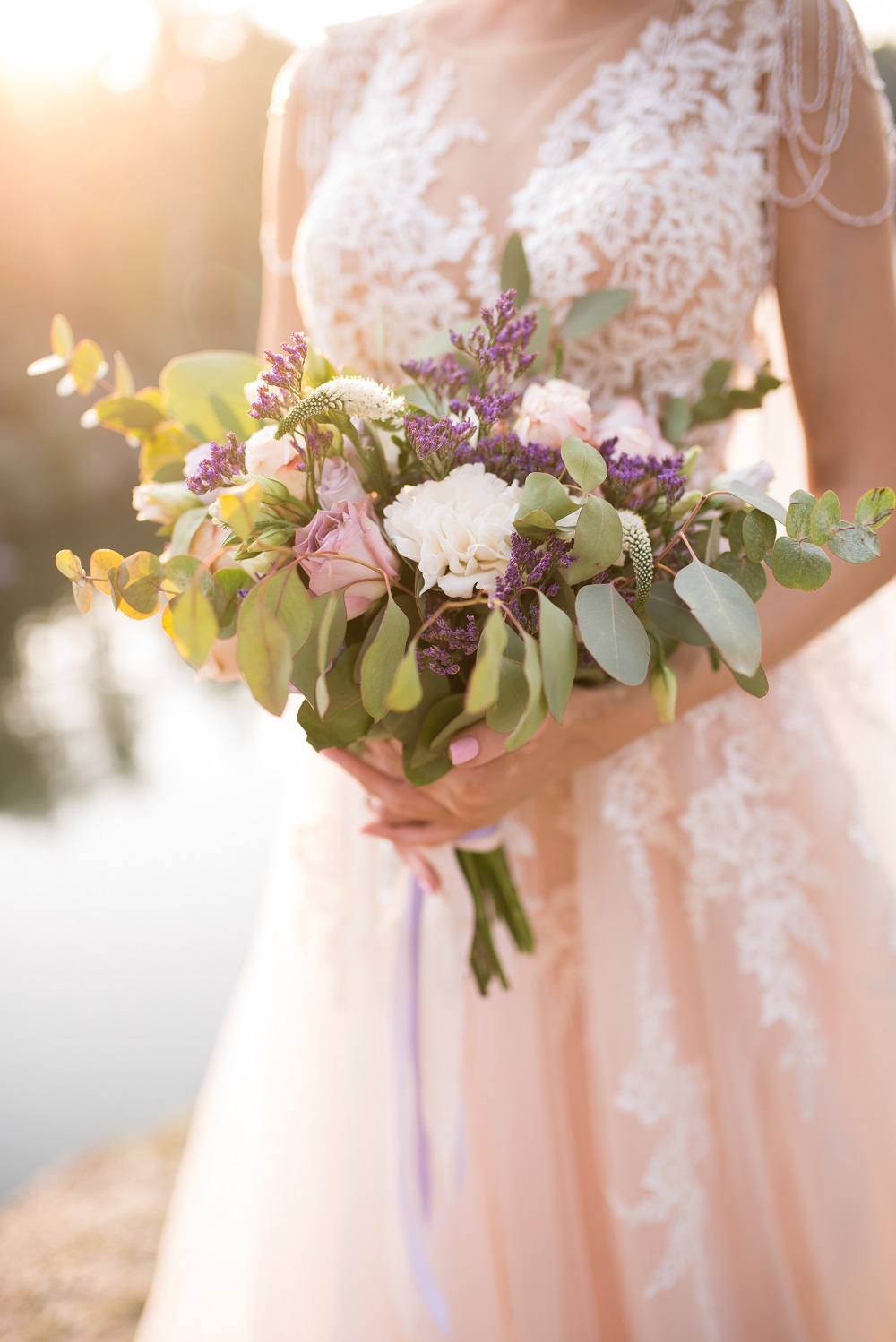 Różowa suknia ślubna. Panna młoda w różowej sukni trzyma bukiet kwiatów.