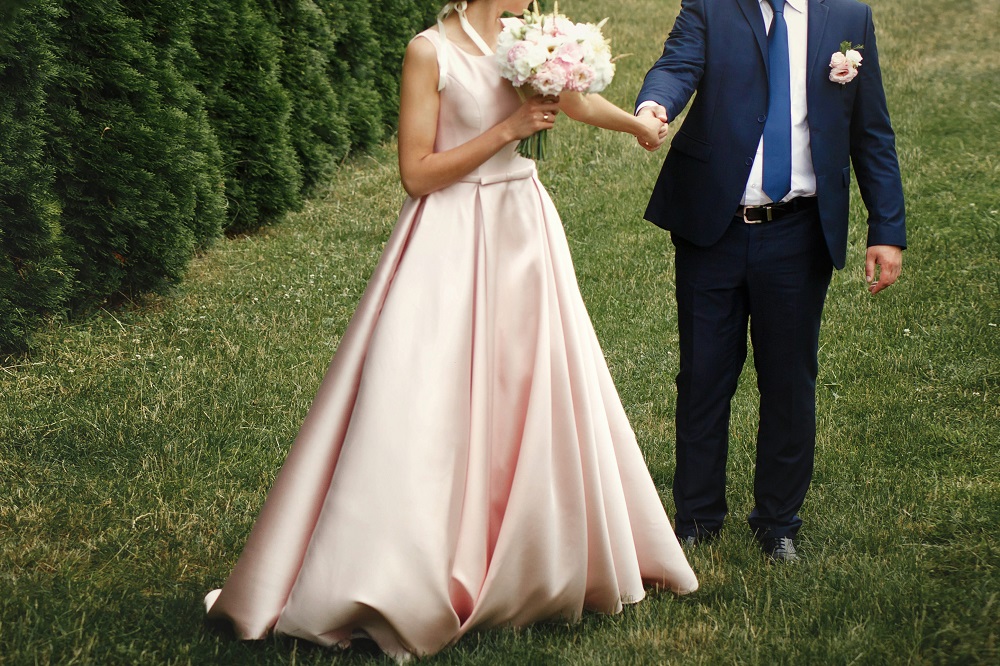 Różowa suknia ślubna. Panna młoda w różowej sukni ślubnej razem z panem młodym na sesji w plenerze.